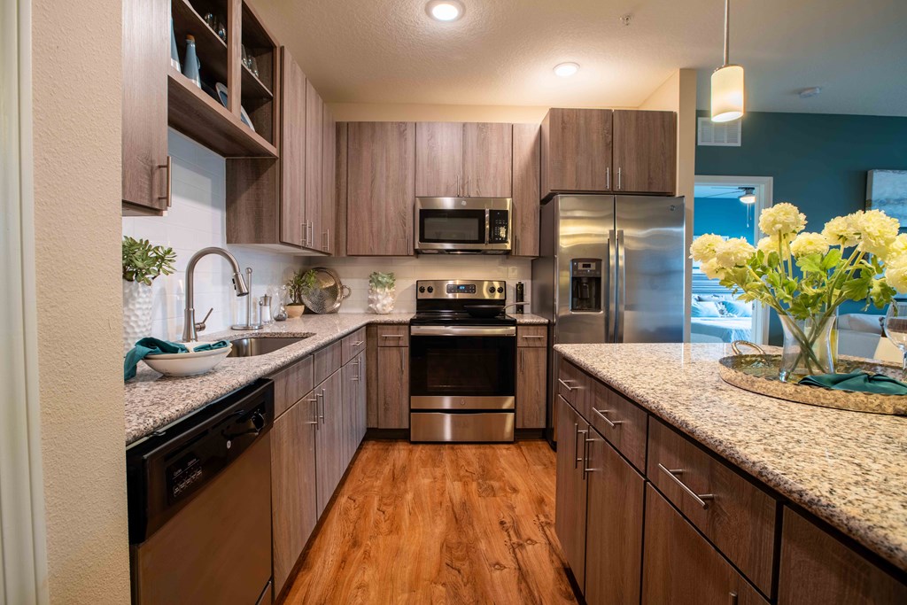 a kitchen with wooden cabinets and stainless steel appliances at Century Dunes Apartments, Deland, 32724