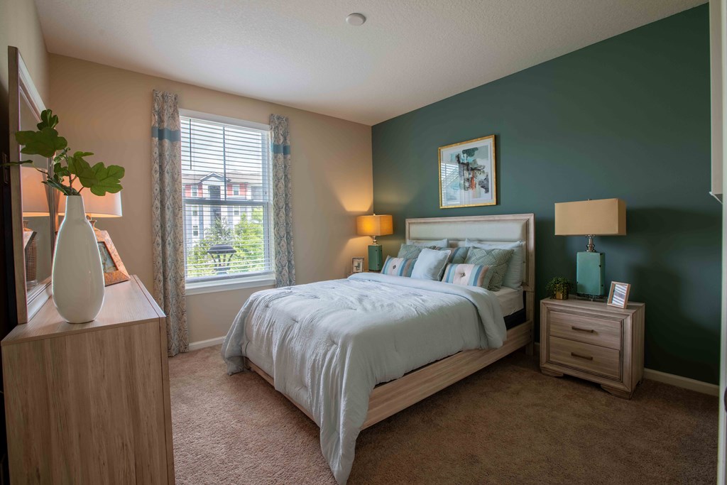 a bedroom with a bed and a window at Century Dunes Apartments, Deland