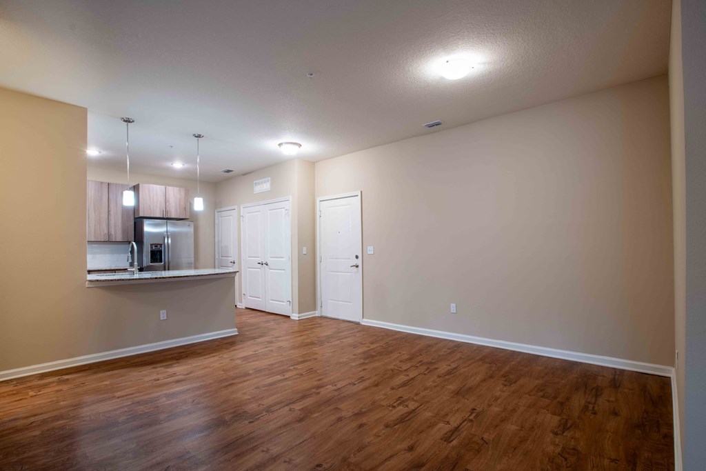 an empty living room and kitchen with wood flooring at Century Dunes Apartments, Deland, FL, 32724