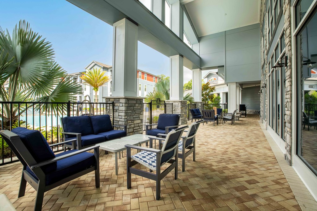 a lobby with tables and chairs and a balcony at Century Dunes Apartments, Florida