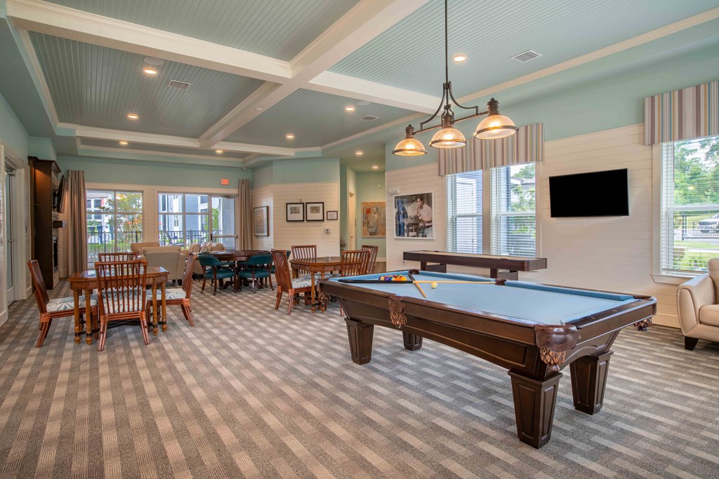 a game room with a pool table and tables at Century Dunes Apartments, Deland, Florida