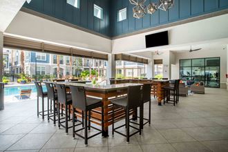 a large bar with chairs and tables in a clubhouse