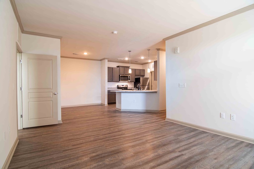 an empty living room and kitchen with a wood floor  at Century New Holland, Gainesville, 30501