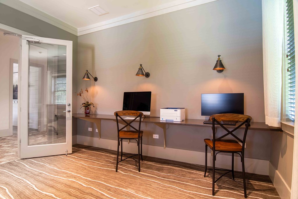 a room with a desk with two chairs and a television at Century New Holland, Gainesville, GA, 30501