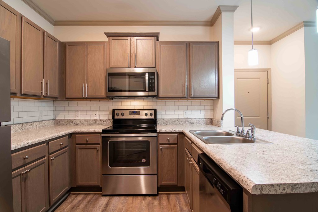 a kitchen with stainless steel appliances and marble counter tops at Century New Holland, Gainesville, GA