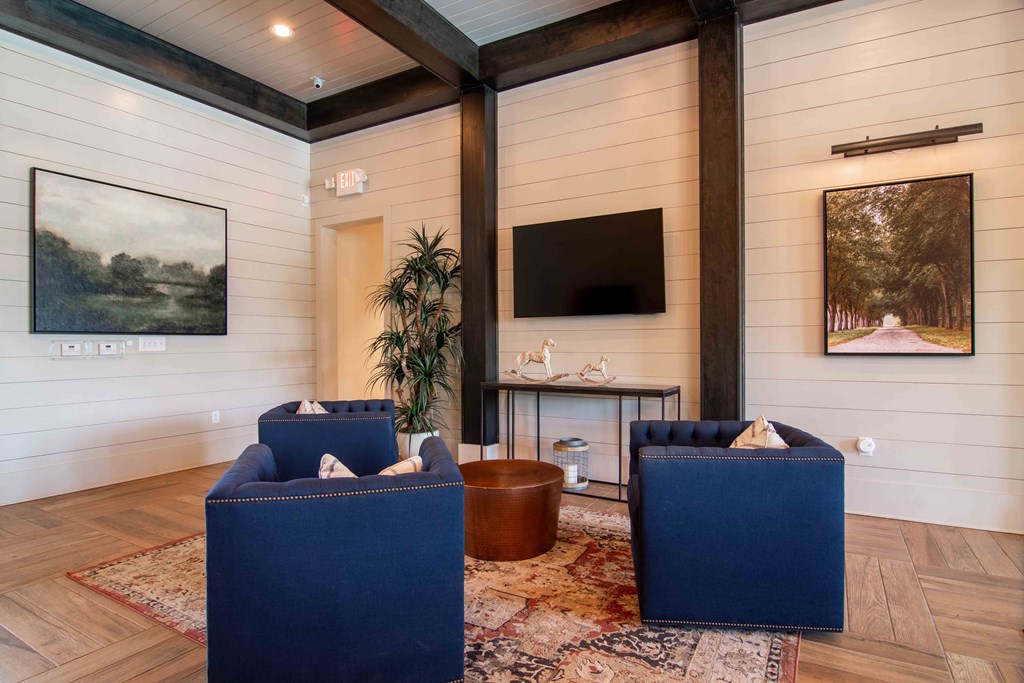 a living room with blue chairs and a tv at Century New Holland, Gainesville, Georgia