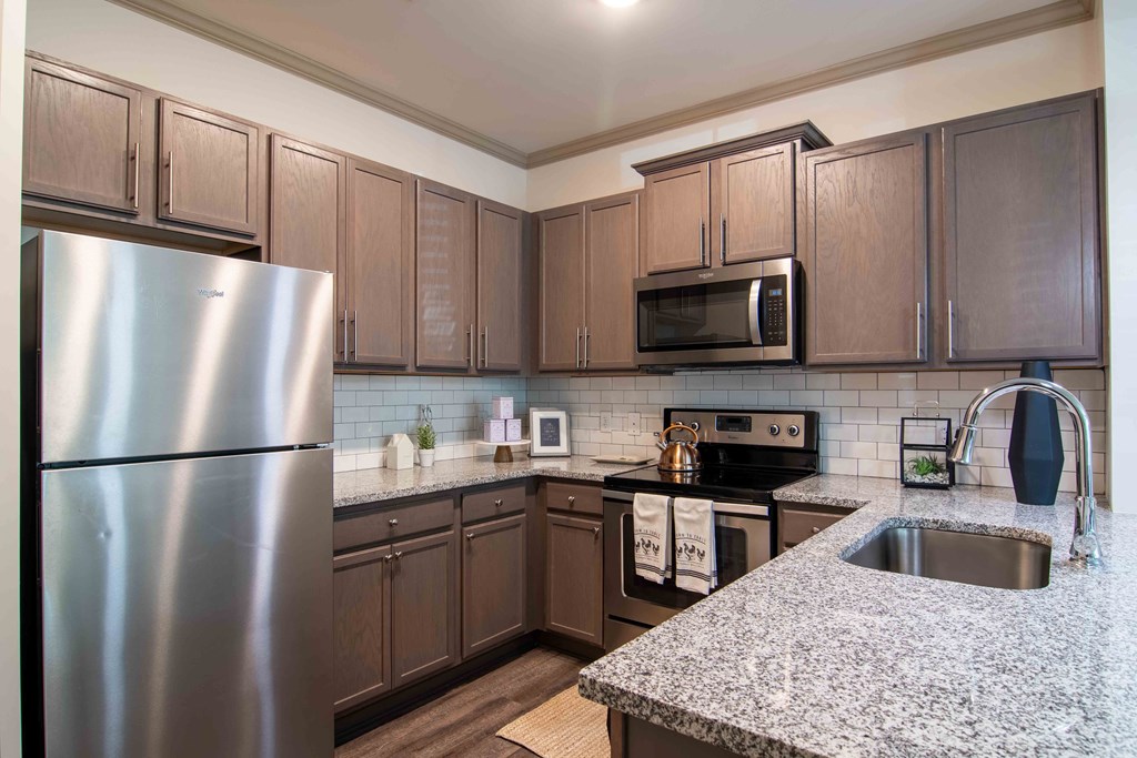 a kitchen with stainless steel appliances and granite counter tops at Century New Holland, Gainesville, Georgia