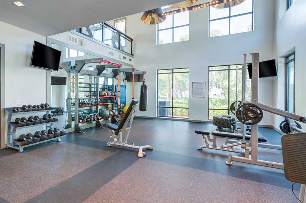 a gym with weights and other equipment and windows at Century Town Center, Gainesville, Florida