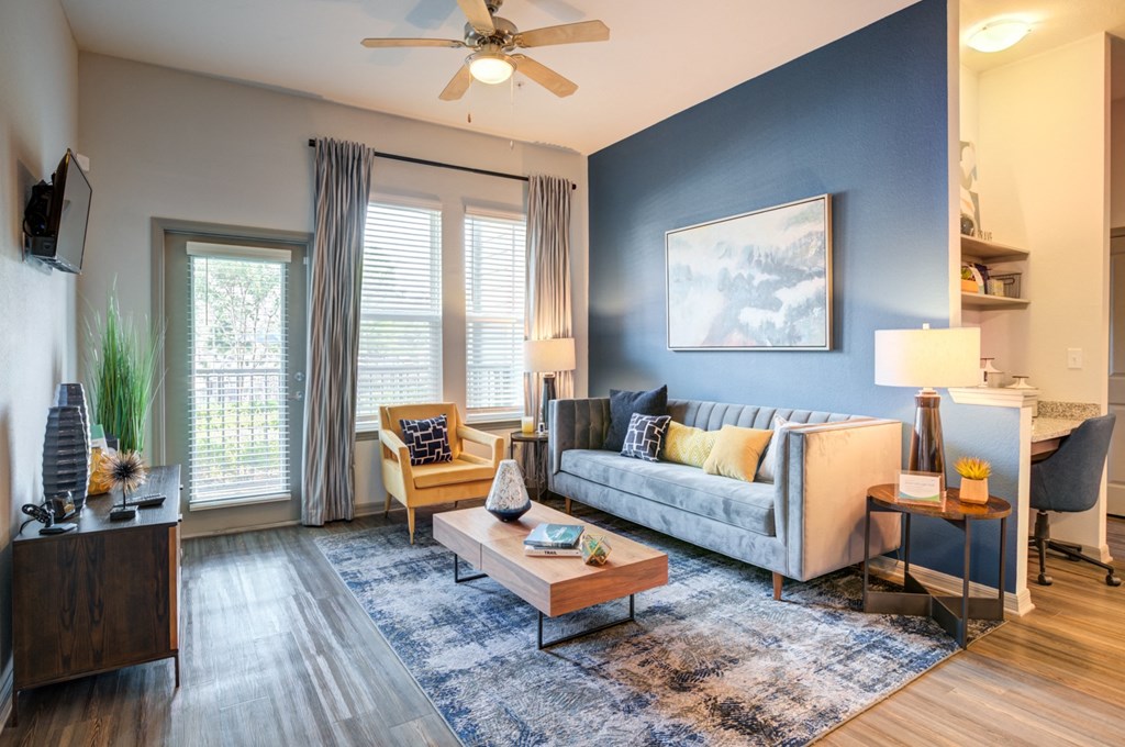an open living room with blue walls and a ceiling fan at Century Town Center, Gainesville, FL