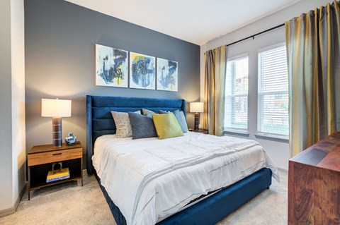 a blue and white bed in a bedroom with windows at Century Town Center, Gainesville, 32607