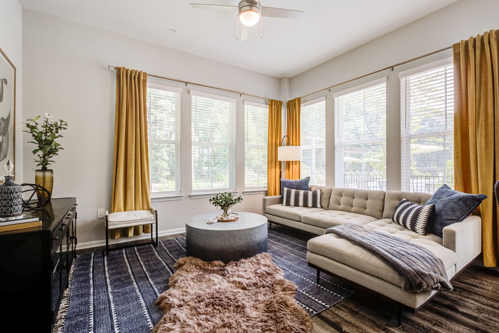 a living room with yellow curtains and a white couch at Century University City, Charlotte, NC