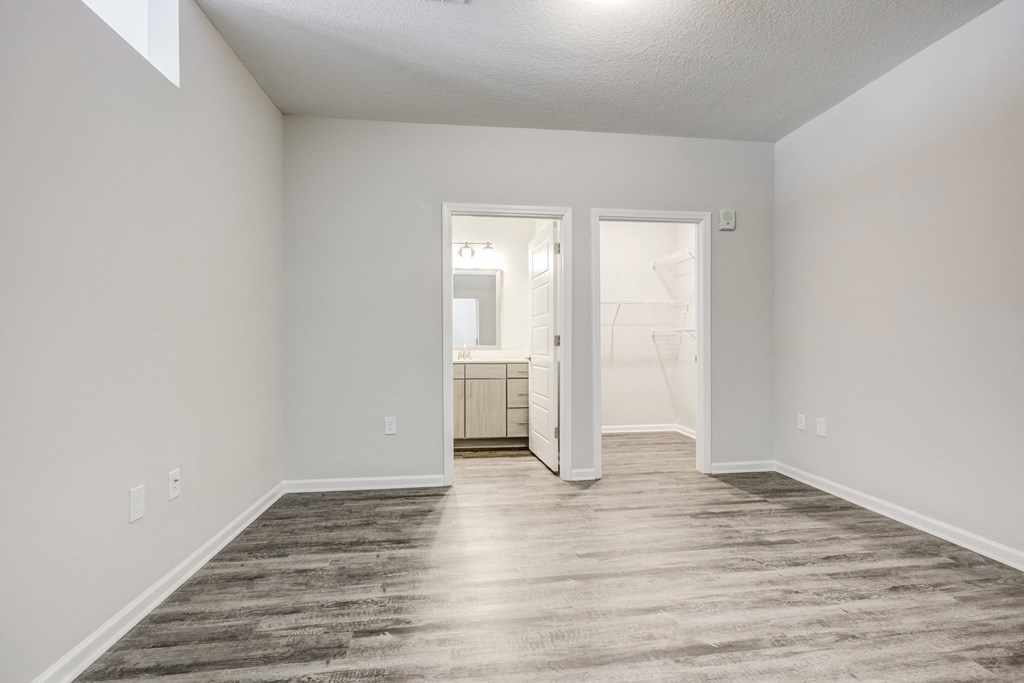 a bedroom with gray walls and a wooden floor at Century University City, Charlotte, 28213