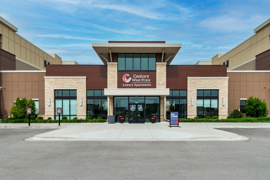a large building with a sign on the front of it  at Century West Pryor, Lee's Summit, MO