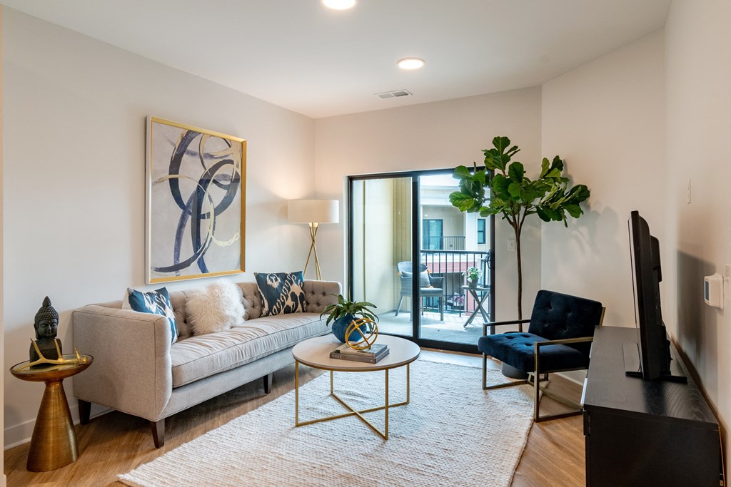 a living room with a couch coffee table and chair and a sliding glass door to a balcony  at Century West Pryor, Missouri, 64081