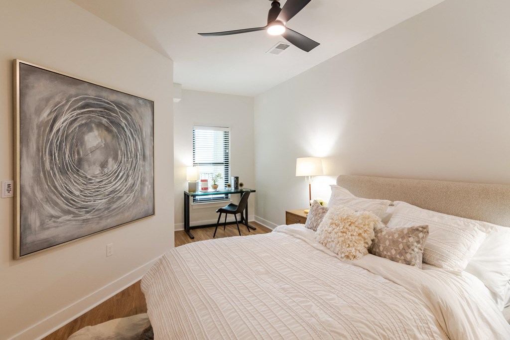a bedroom with a large bed and a ceiling fan  at Century West Pryor, Lee's Summit