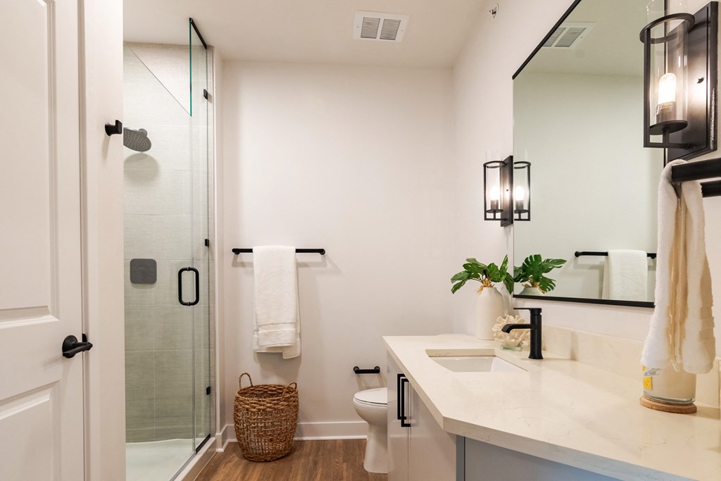 a bathroom with white walls and a large mirror  at Century West Pryor, Lee's Summit, 64081