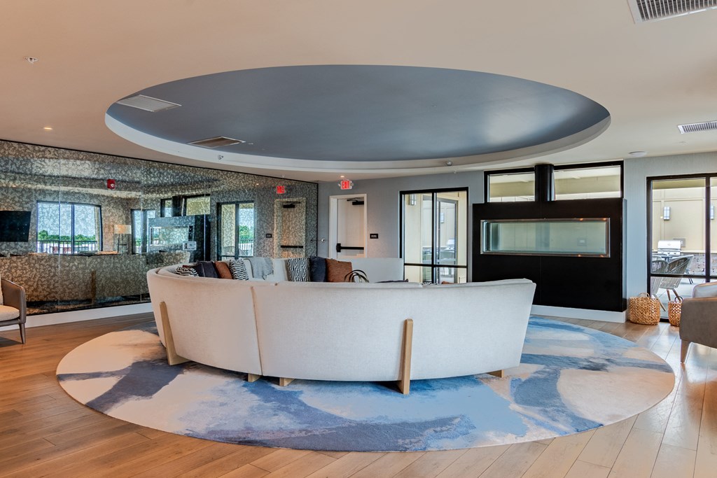 a living room with a large white couch and a blue rug  at Century West Pryor, Lee's Summit, MO
