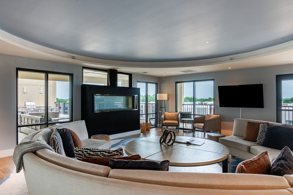 a living room filled with furniture and a flat screen tv  at Century West Pryor, Lee's Summit, MO