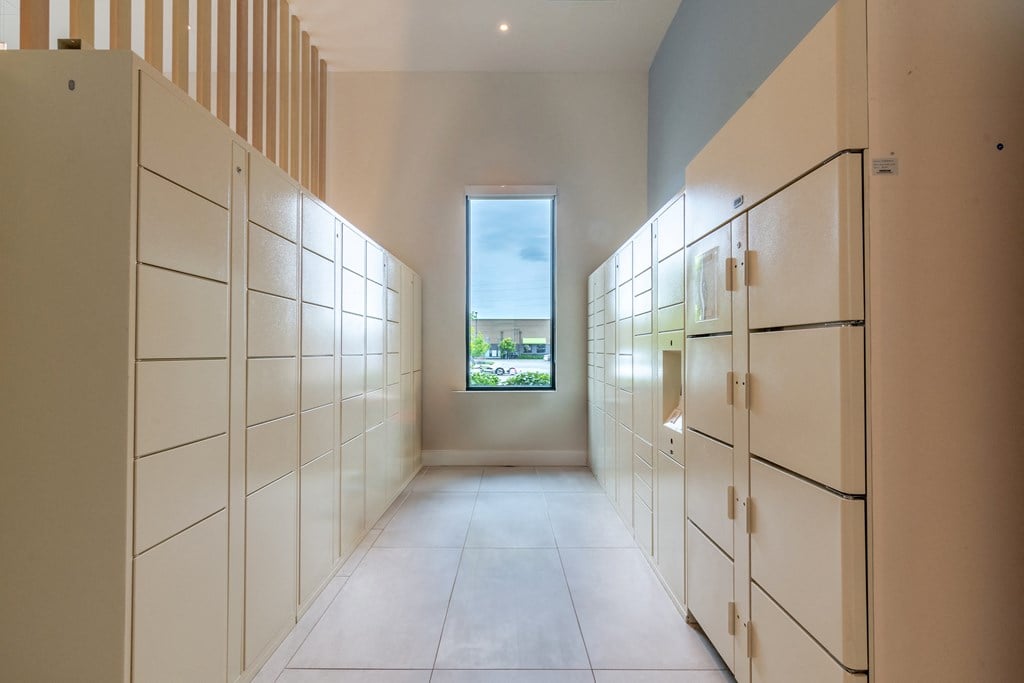 a long walkway with white cabinets and a window at the end  at Century West Pryor, Lee's Summit, MO