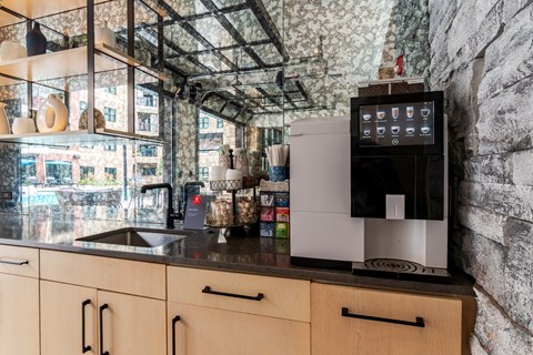 a kitchen with a sink and a coffee maker on the counter