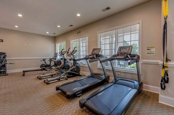the gym is equipped with cardio equipment and windows
