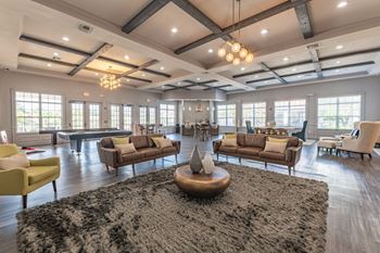 a living room with couches and chairs and a ping pong table
