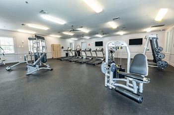 spacious gym with cardio equipment and weights at the enclave at woodbridge apartments