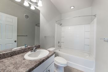 a bathroom with a sink and a tub and a mirror