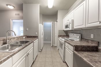 a kitchen with white cabinets and granite counter tops