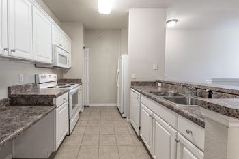 a kitchen with white cabinets and granite counter tops