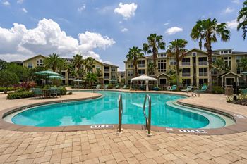 a large swimming pool with apartments in the background