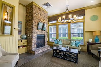 a living room with a stone fireplace and a coffee table