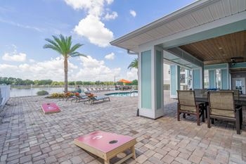 a patio with a pool and chairs and tables