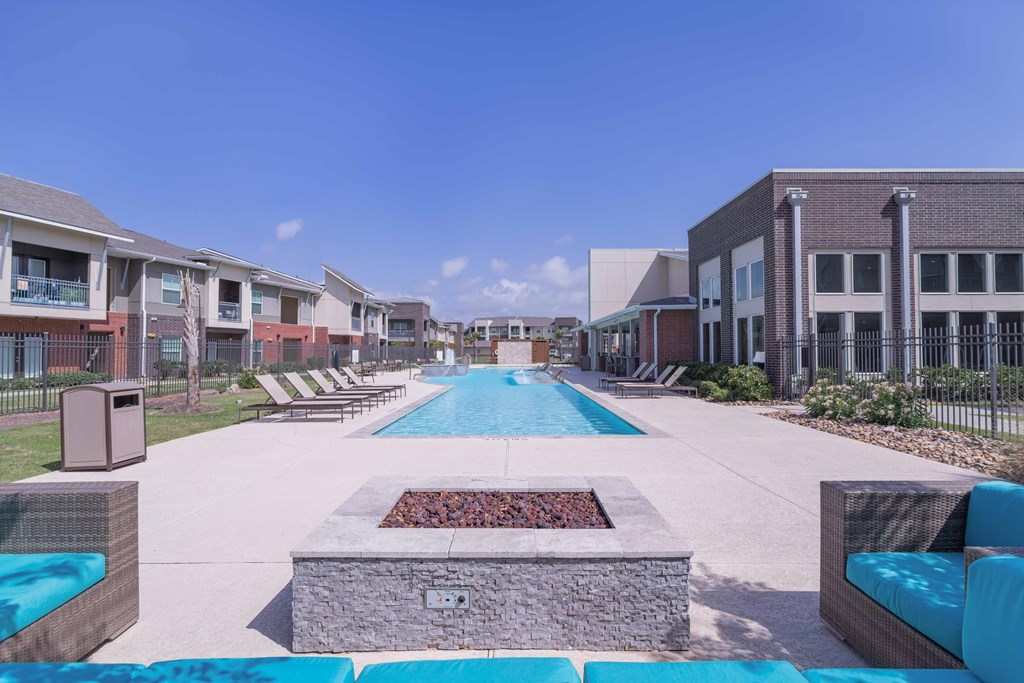 our apartments have a large pool with lounge chairs and a fire pit at Century Palm Bluff, Portland, TX