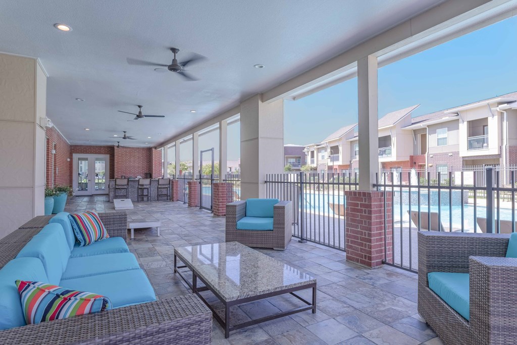 a patio with couches and chairs and a pool at Century Palm Bluff, Portland, 78374