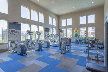 a gym with cardio equipment and windows in a building at Century Palm Bluff, Portland, TX, 78374