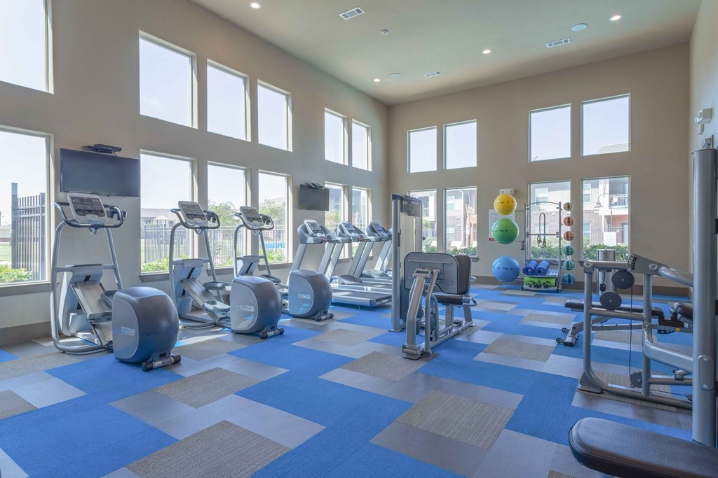 a gym with cardio equipment and windows in a building at Century Palm Bluff, Portland, TX