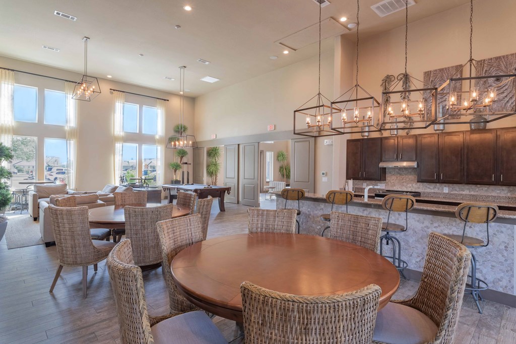 a large dining room with tables and chairs and a kitchen at Century Palm Bluff, Portland, Texas