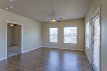 an empty living room with a ceiling fan and windows at Century Palm Bluff, Portland, 78374