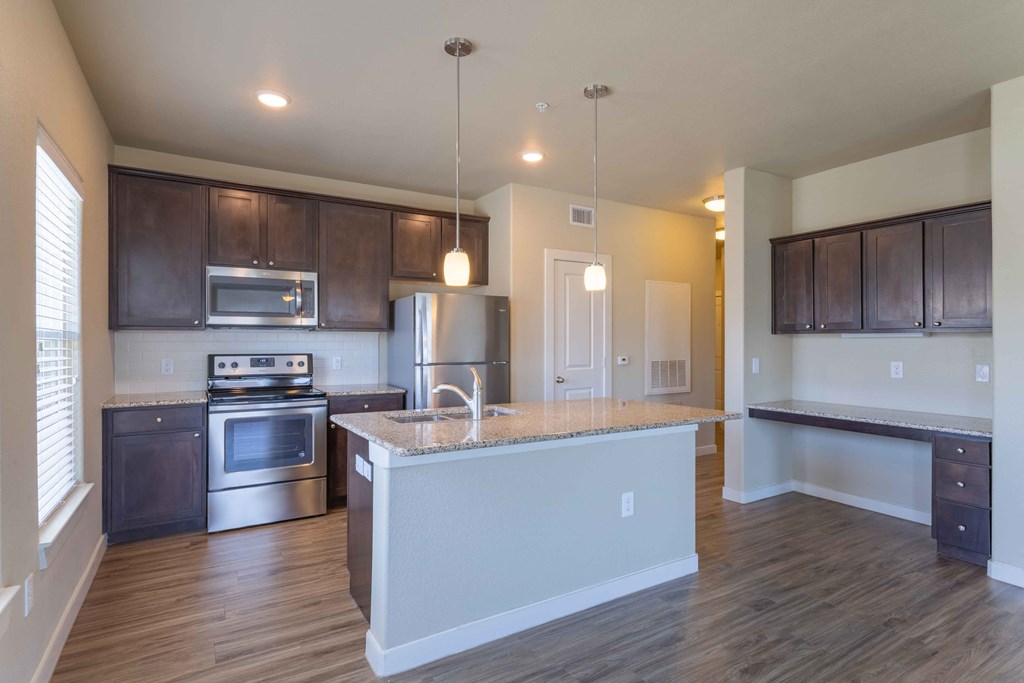a kitchen with a large island and a stove and a refrigerator at Century Palm Bluff, Portland, TX