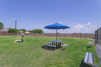a patio with a picnic table and an umbrella in a backyard at Century Palm Bluff, Portland