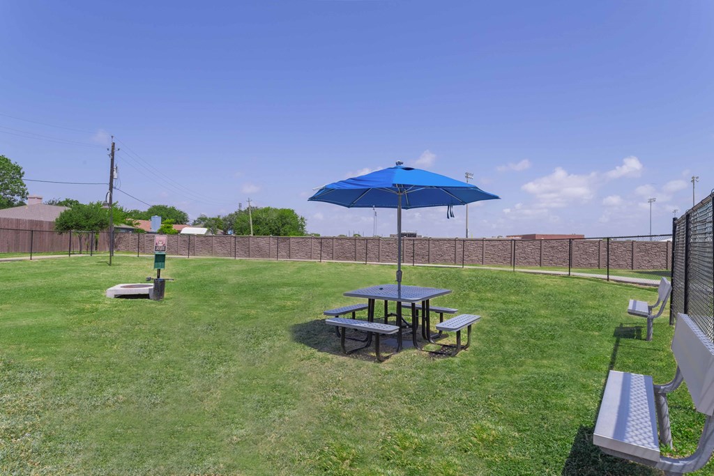 a picnic table with an umbrella in a yard at Century Palm Bluff, Portland, TX