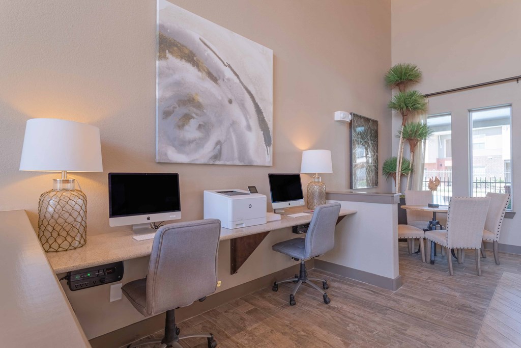 a desk with two computers and chairs in a room with a window at Century Palm Bluff, Portland