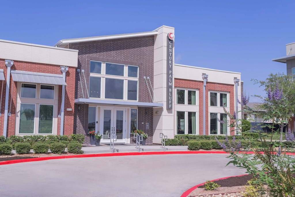 the front of a brick building with a red curb and a driveway at Century Palm Bluff, Portland, 78374