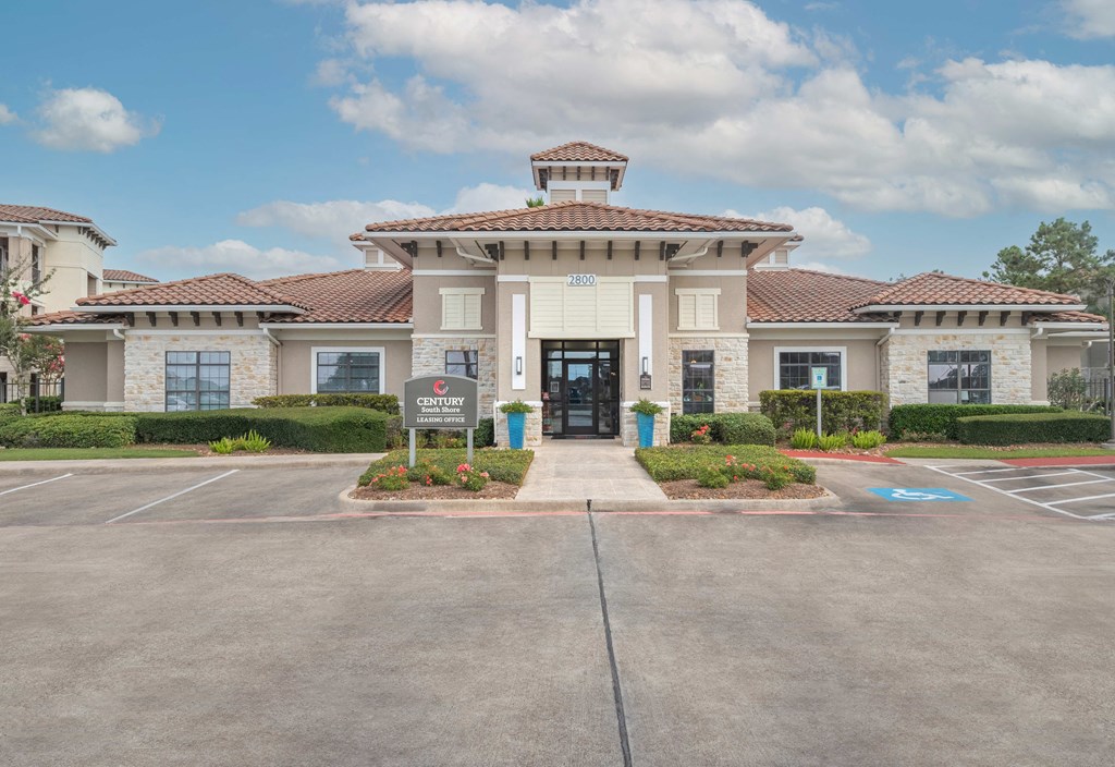 a large white building with a sign in front of it at Century South Shore, League City, Texas