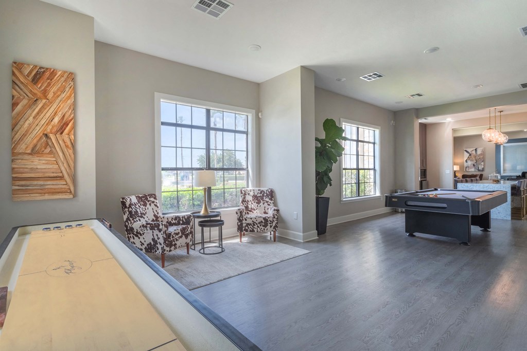a living room with a pool table and two chairs at Century South Shore, League City, TX, 77573