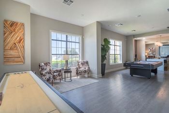 a living room with a pool table and two chairs at Century South Shore, Texas