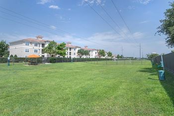 a large grassy area with houses in the background at Century South Shore, League City, TX