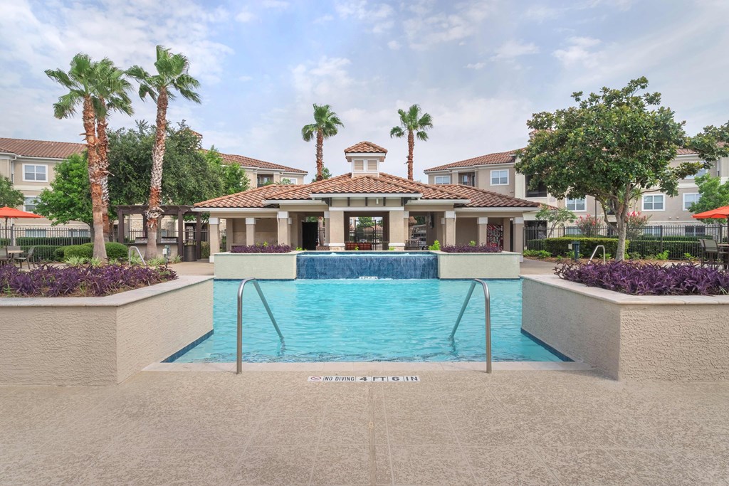 a pool with a building in the background  at Century South Shore, League City, Texas
