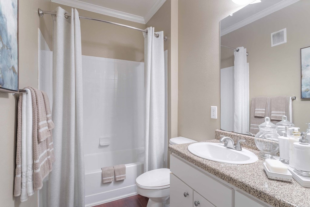 a bathroom with a shower toilet and sink at Century South Shore, League City